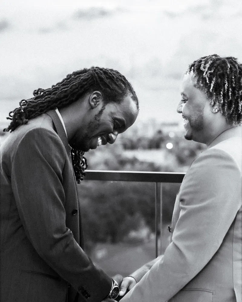 Black and white photo of two men laughing together on a downtown Houston rooftop